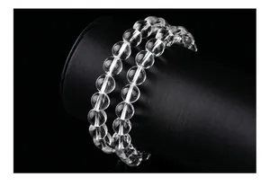 Vue macro d'un bracelet en perles de cristal de roche naturel sur un support d'exposition noir