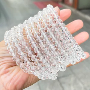 Mano che tiene vari braccialetti di perle di cristallo di rocca sfaccettate