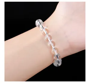 Bracelet en perles de quartz clair naturel au poignet avec une grande transparence