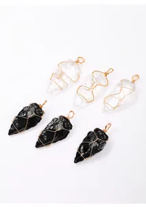 Detailed view of hand-wrapped copper wire on spear-shaped clear and black crystal pendants.