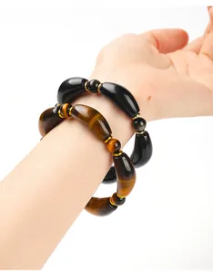 Detailed close-up of natural tiger eye and gold obsidian curved tube bead bracelets