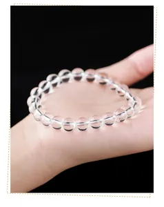 Gros plan d'un bracelet en perles de quartz clair naturel de haute qualité sur une main
