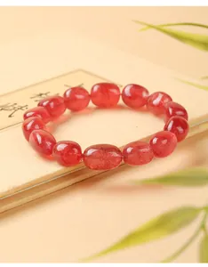 Vista macro de cuentas de pepita de cuarzo fresa natural en una pulsera de cristal rosa