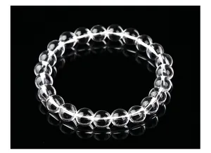 Gros plan de perles de cristal blanc naturel hautement transparentes sur fil élastique
