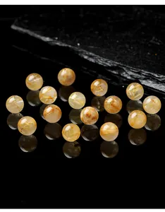 Vista macro di perle tonde in quarzo rutilato dorato trasparente per creare gioielli