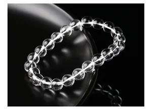 Détail macro d'un bracelet en perles de cristal blanc naturel sur fond noir