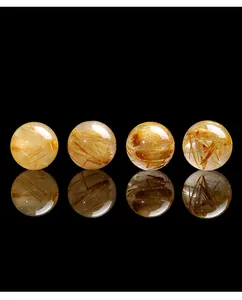 Macro dettagliata di quattro perle di quarzo rutilato dorato trasparente su sfondo nero