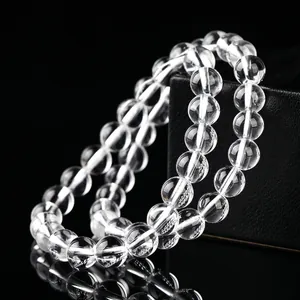 Élégant bracelet en perles rondes de cristal de quartz clair naturel sur fond noir