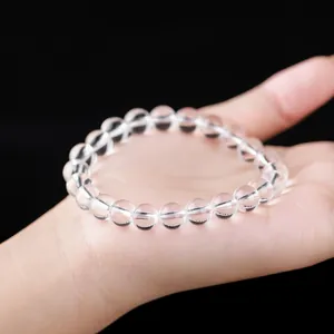 Bracelet en perles de cristal de quartz blanc naturel présenté sur une main