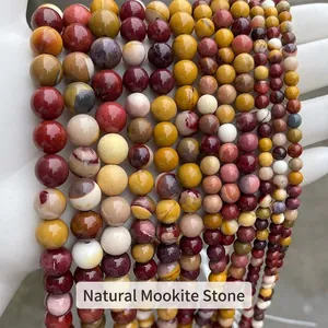 Vue détaillée de rangs de perles rondes lisses en jaspe mookaïte naturel multicolore
