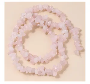 Gedetailleerde close-up van onregelmatige natuurlijke rozenkwarts kristalchips voor sieraden