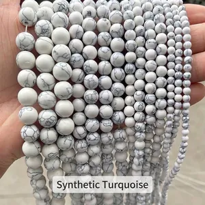 Vue macro détaillée montrant plusieurs fils de perles rondes en turquoise blanche