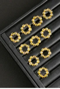 Plusieurs anneaux en quartz rutile doré naturel sur un plateau de présentation noir