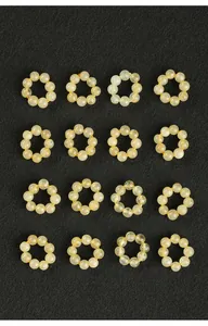 Vue rapprochée de plusieurs bagues en perles de quartz rutilé doré naturel sur fond noir.