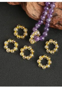 Vue détaillée de bagues en perles de quartz rutile doré naturel sur fond sombre.