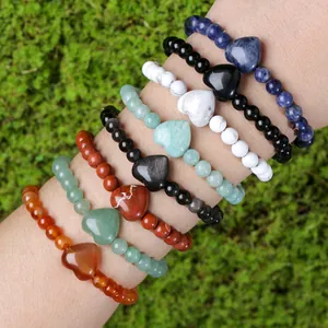 Natuurlijke kristallen en jade hartvormige kralenarmbanden gepresenteerd op een arm