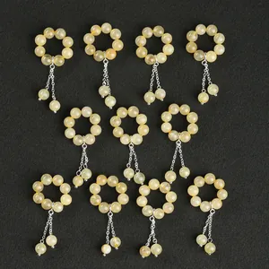Bagues en perles de quartz rutilé doré naturel avec pompons sur fond noir.