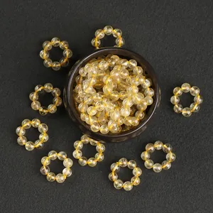 Perles et anneaux en quartz rutilé doré naturel présentés sur un fond sombre texturé