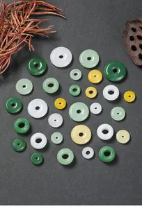 Detailopname van diverse glazen donut-bedels in imitatie wit en groen jade afwerking