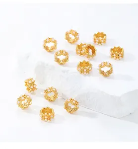 Vista detallada de cuentas espaciadoras de flores doradas con perlas para DIY