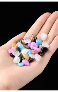 Assorted colorful heart-shaped natural gemstones held in palm on black background