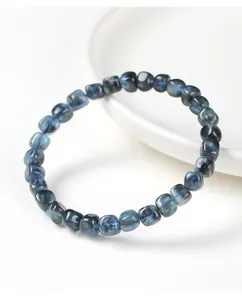 Gedetailleerde macro-weergave van aquamarijnkralen met blauwe flits op armband