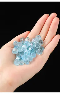 Detail showing faceted light blue topaz gemstones held in palm for scale comparison