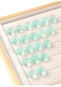Macro view of translucent natural green fluorite pumpkin-shaped loose beads on velvet tray