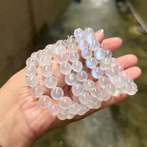 Gros plan d'un bracelet en pierre de lune bleue naturelle avec des perles laiteuses.