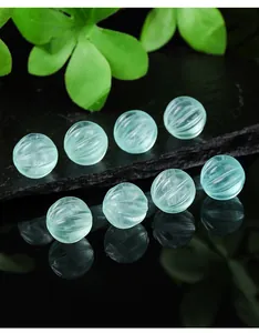 Macro detail of natural translucent green fluorite pumpkin-shaped carved loose beads
