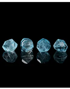 Macro view of natural blue topaz gemstones with irregular faceted cuts on black surface