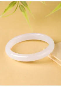 Close-up van een elegante witte agaat armband op een warme getextureerde basis