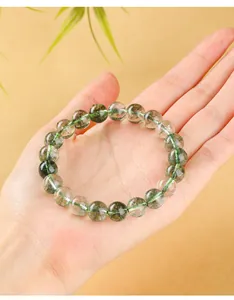 Gros plan d'un bracelet en quartz fantôme vert naturel de haute qualité tenu dans la main