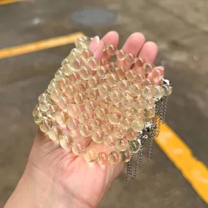 Detailansicht von natürlichen Zitronencitrin-Perlenarmbändern mit silbernen Quasten.