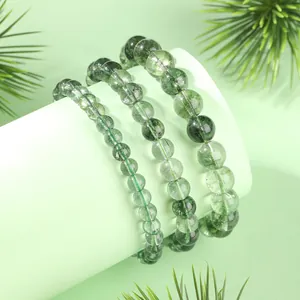 Bracelets en cristal de quartz fantôme vert naturel avec perles rondes sur fond vert