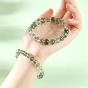 Bracelet en cristal de quartz fantôme vert de qualité supérieure porté sur une main