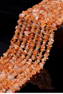 Close-up macro detail of natural orange sunstone chips showing shimmering aventurescence texture