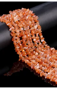 Close-up of natural orange sunstone chips for DIY jewelry making with sparkling texture