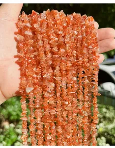 Detailed macro view of natural orange sunstone gravel beads with irregular shapes