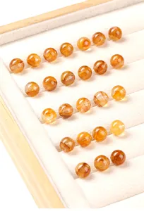 Gros plan de perles rondes en quartz hématogène jaune et rouge sur plateau bijoux