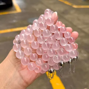 Gros plan de perles de quartz rose naturel avec de délicats charms en chaîne argentée.