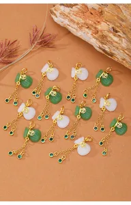 Detalle de dijes de bolsa de fortuna en oro con imitación de jade y borlas de circón verde.