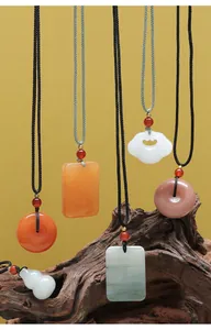 Collection de colliers avec pendentifs en jade, boucles de paix et verrous Ruyi sur bois.