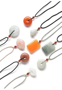 Collection de divers pendentifs en pierre de jade colorés avec motifs de boucle de paix