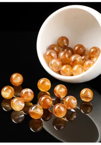 Vue détaillée de perles de cristal de quartz amphibole rouge doré naturel poli