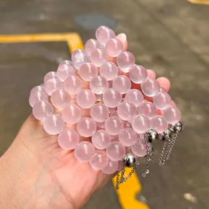 Détail macro de plusieurs bracelets en perles de quartz rose naturel avec breloques argent