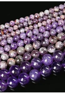 Gros plan détaillé de perles rondes en améthyste naturelle aux nuances violettes.