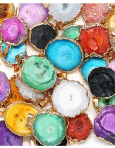 Close-up of colorful irregular agate geode pendants with gilded edges and gold bails
