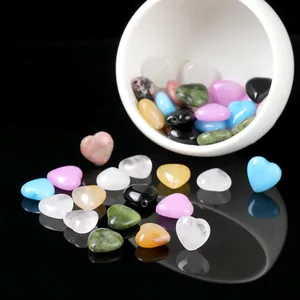 Collection of colorful heart-shaped natural stone beads spilling from a white bowl