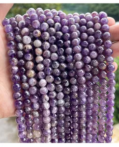 Gros plan de perles rondes en améthyste naturelle aux teintes violettes variées